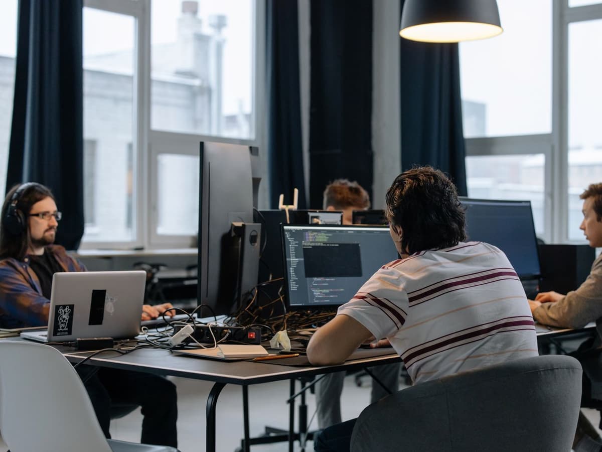 Ontwikkelteam aan het werk achter meerdere schermen